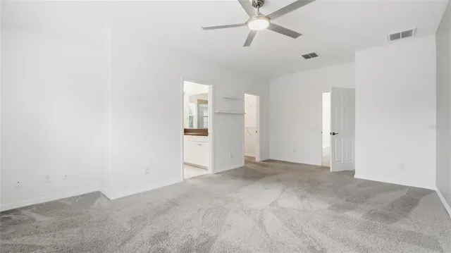 an empty room with closet and fan
