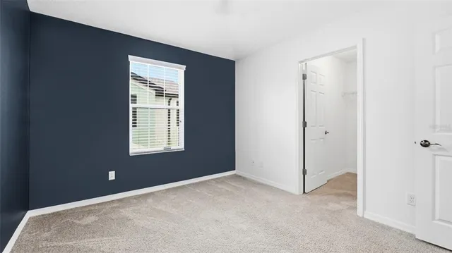 an empty room with a ceiling fan and a window