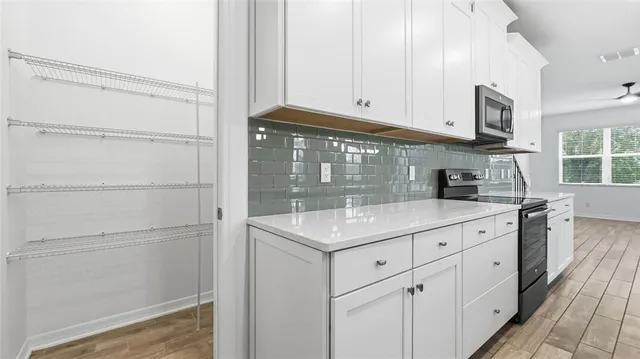 a kitchen with white cabinets and sink