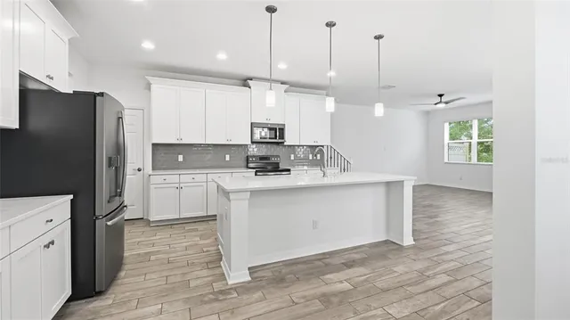 a kitchen with a refrigerator sink and cabinets