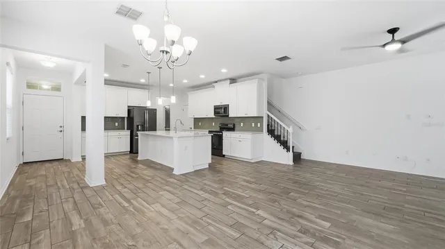 a view of a kitchen with wooden floor and a refrigerator