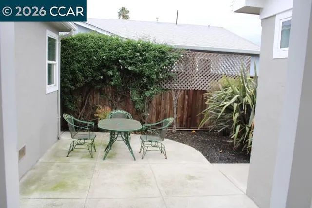 a view of backyard with a table and chairs and potted plants