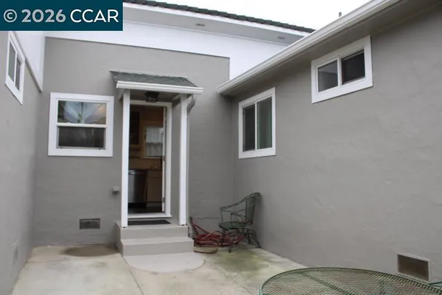 a backyard of a house with table and chairs