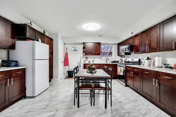 a kitchen with granite countertop a refrigerator and a stove top oven