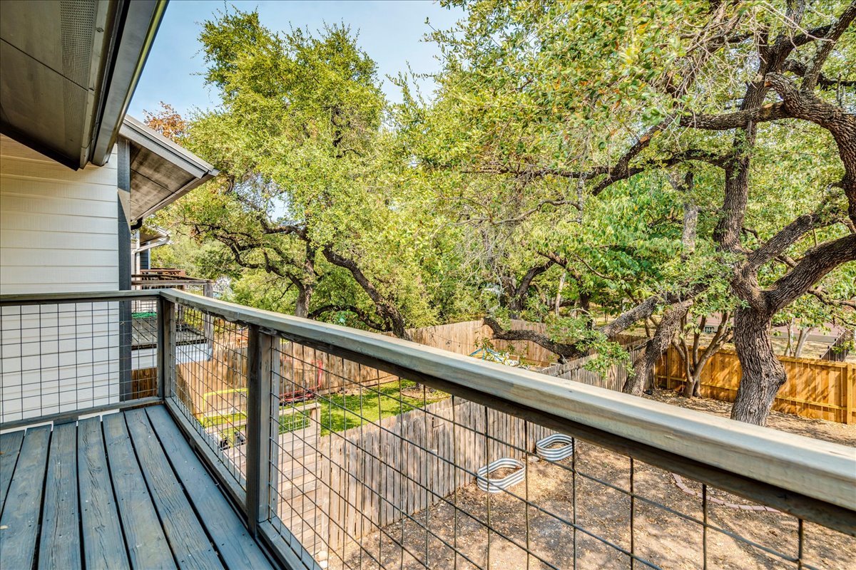 2811 Hardeman Street, Unit B Austin, TX 78704 - Photo 6 of 34 An elevated wood balcony overlooks a private fenced yard shaded by mature trees.