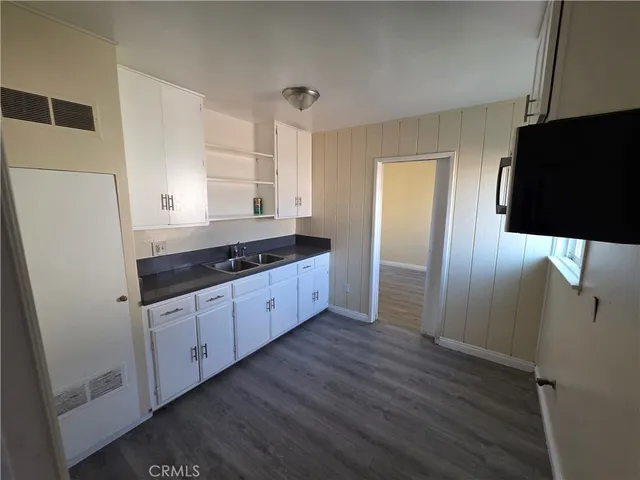 a kitchen with granite countertop a refrigerator and a sink