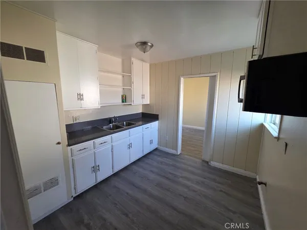 a kitchen with granite countertop a refrigerator and a sink