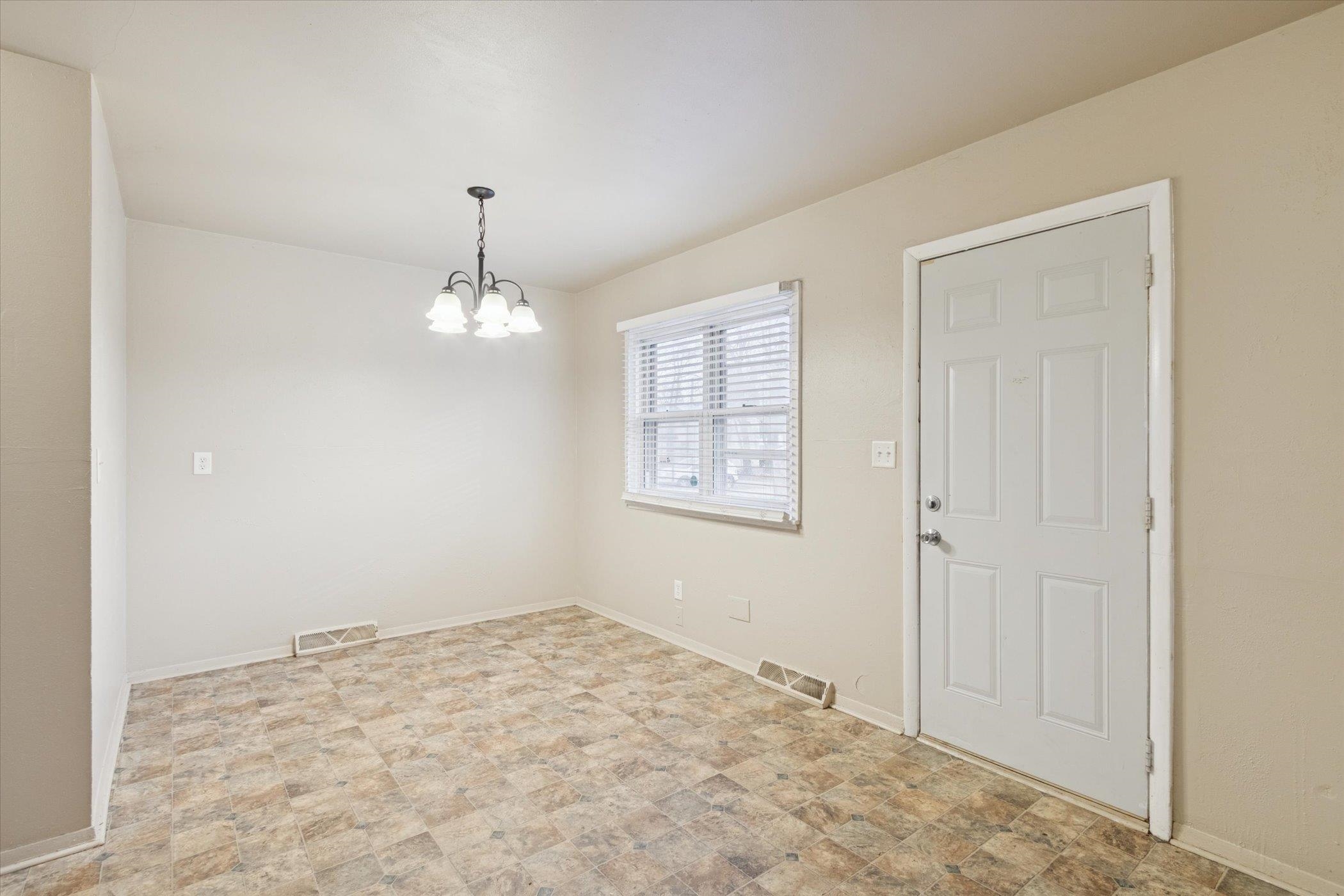 1120 Lincoln Avenue Rockford, IL 61102 - Photo 6 of 12 an empty room with chandelier fan and wooden floor