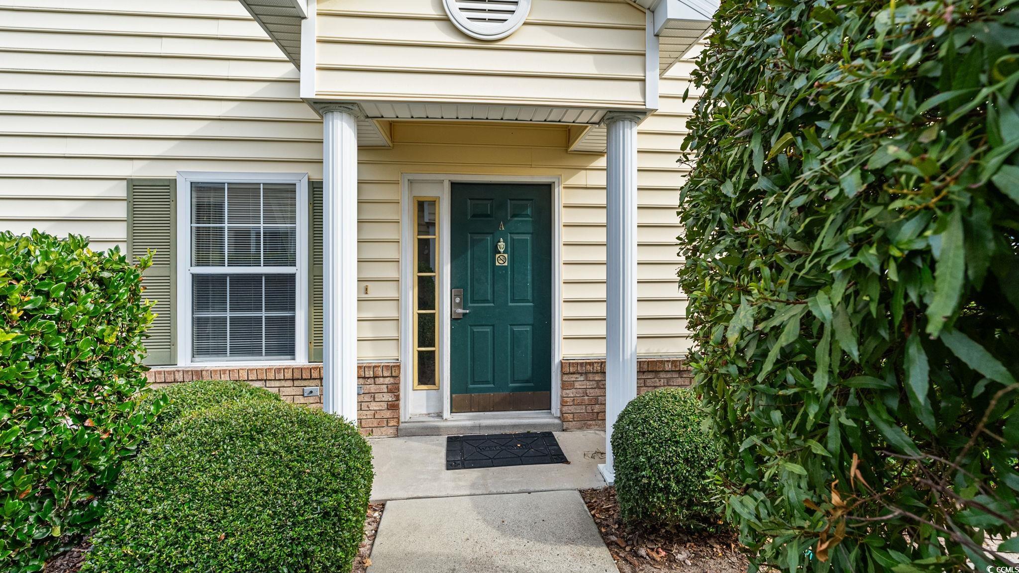 Doorway to property featuring brick siding