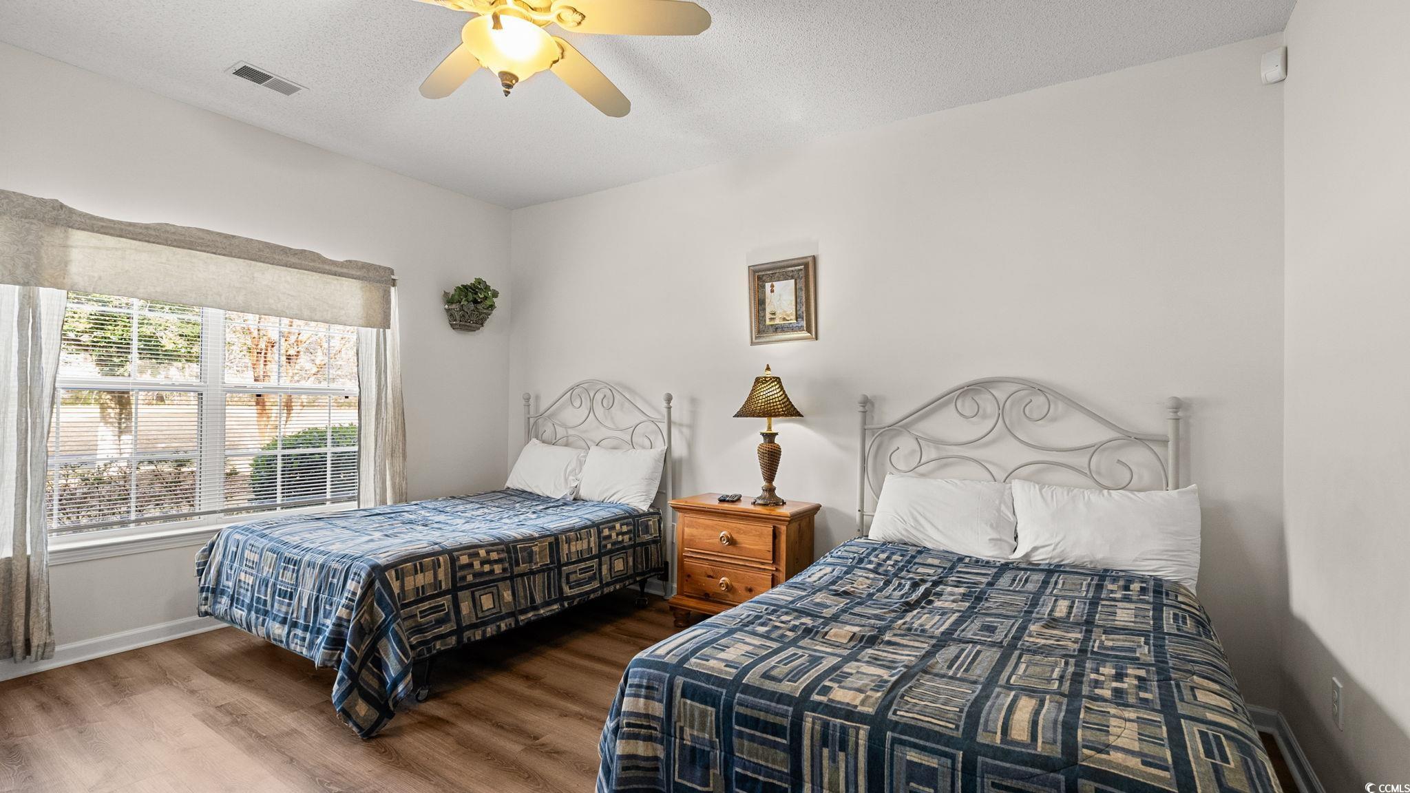 4431 Montrose Lane, Unit A Myrtle Beach, SC 29579 - Photo 14 of 32 Bedroom with a textured ceiling, a ceiling fan, and wood finished floors