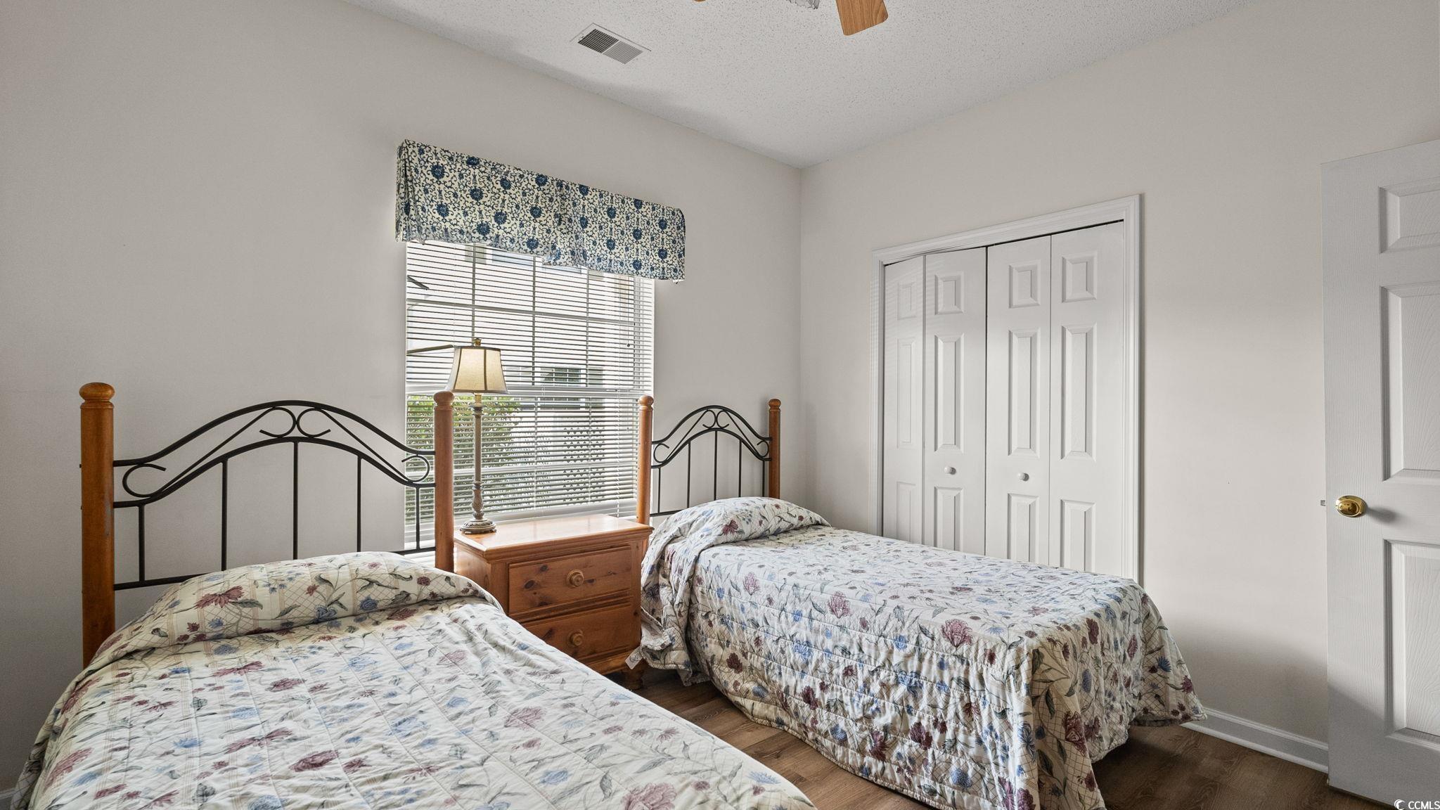 4431 Montrose Lane, Unit A Myrtle Beach, SC 29579 - Photo 21 of 32 Bedroom with dark wood-type flooring, a closet, a ceiling fan, and a textured ceiling