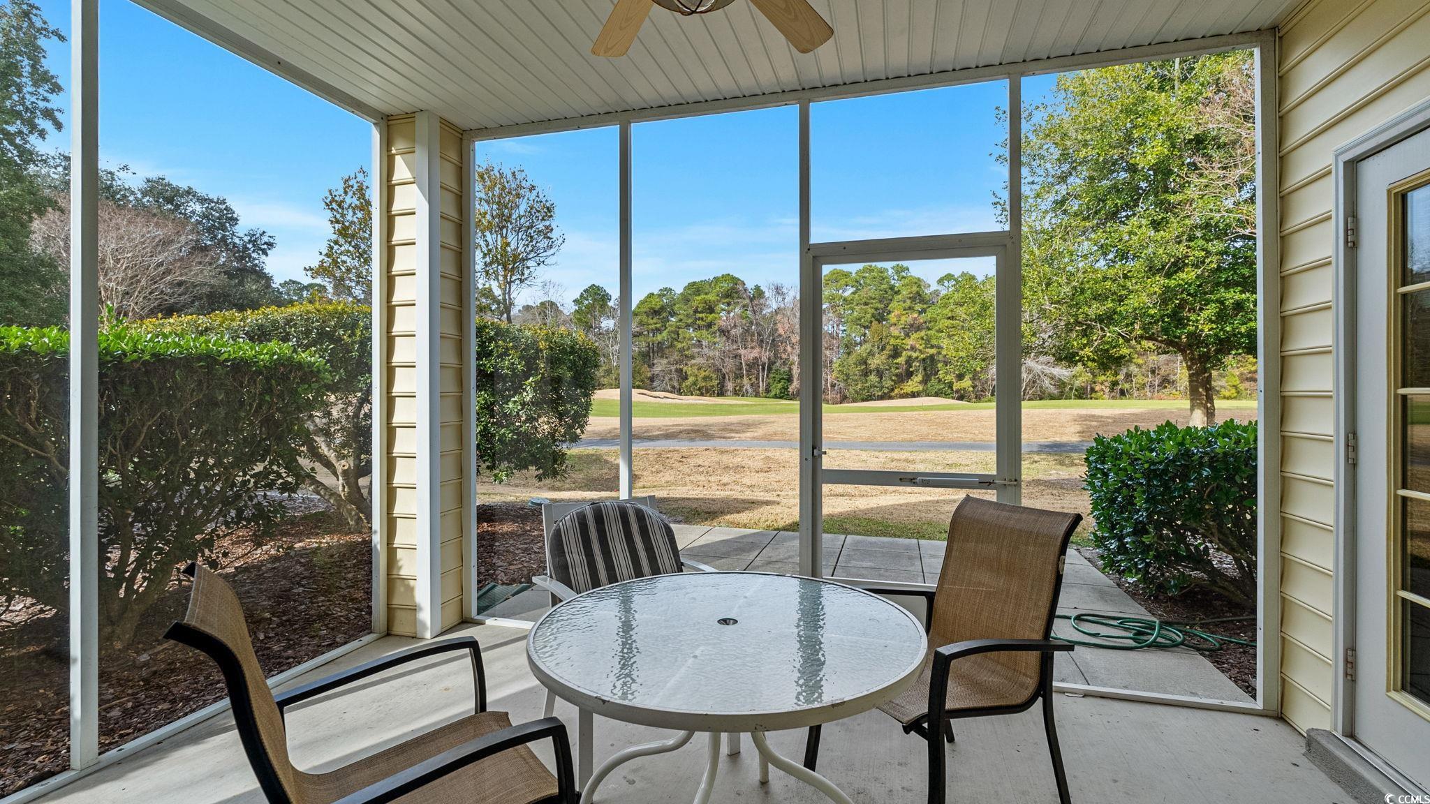 4431 Montrose Lane, Unit A Myrtle Beach, SC 29579 - Photo 5 of 32 Sunroom with a ceiling fan, outdoor dining space, and view of wooded area