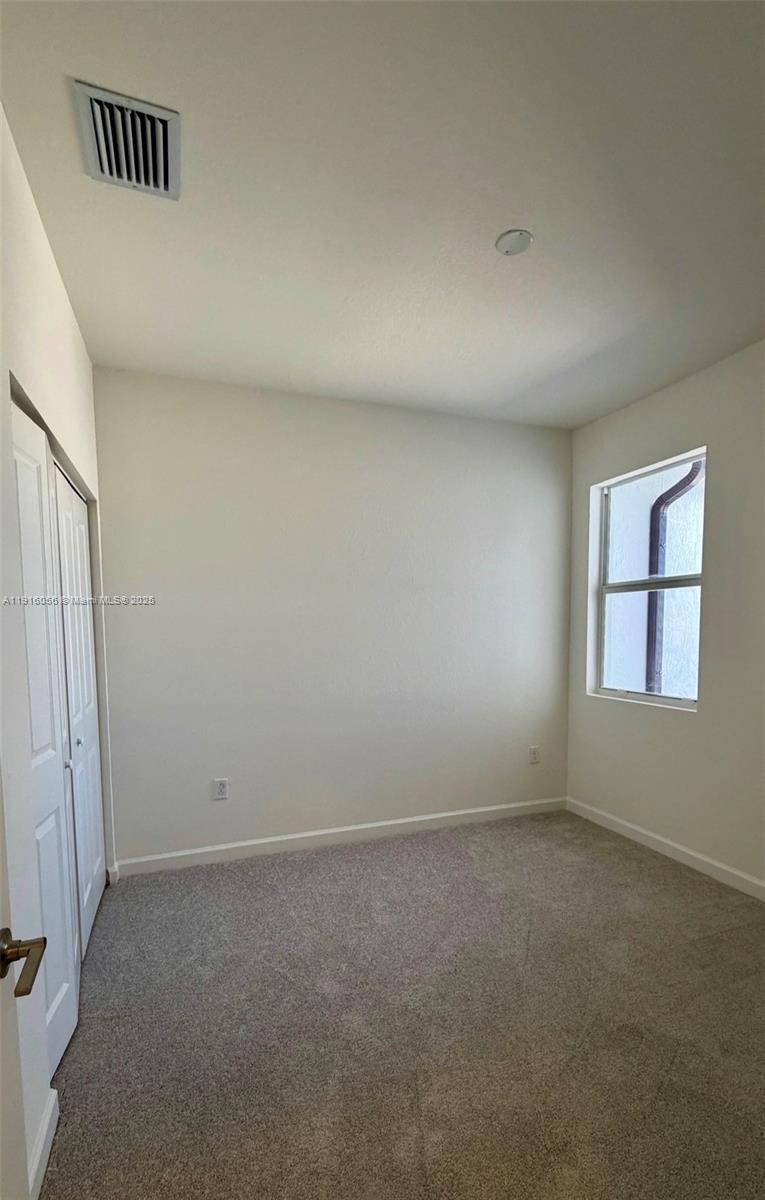 15592 Southwest 276th Terrace Homestead, FL 33031 - Photo 8 of 12 an empty room with windows