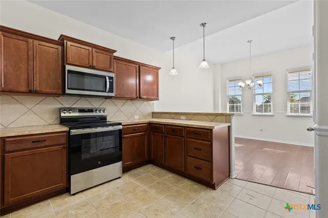 a kitchen with granite countertop wooden cabinets and stainless steel appliances