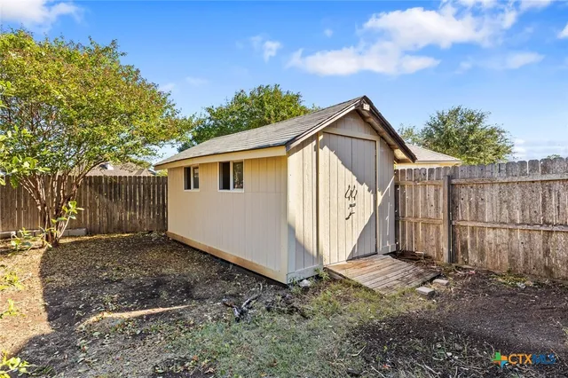 a view of a yard with plants and trees