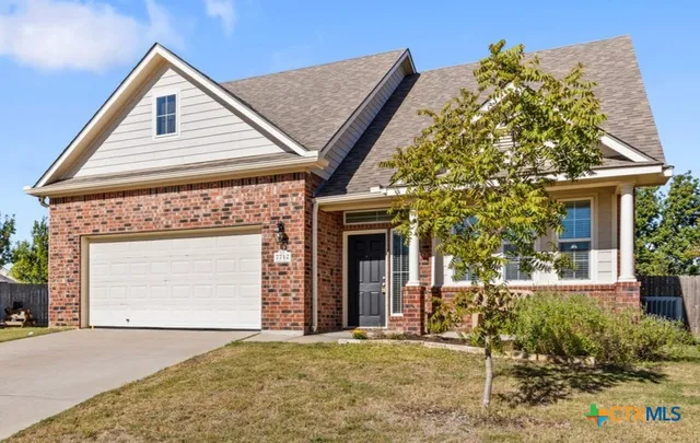 a front view of a house with a garden and plants