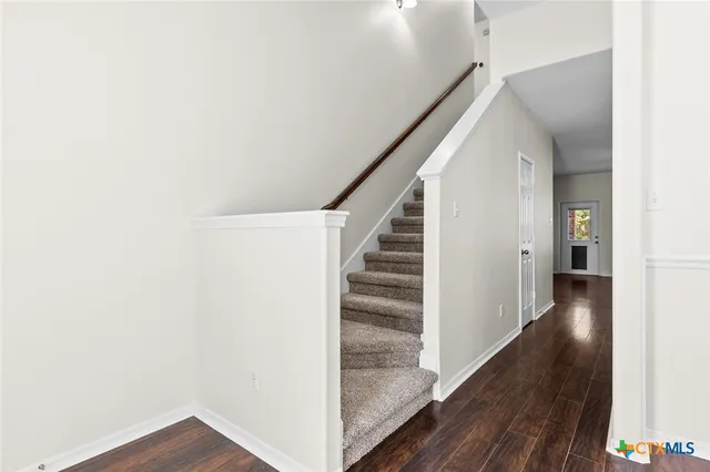 a view of a hallway with wooden floor and entryway