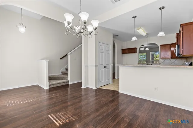 a view of a kitchen with a sink wooden floor and a chandelier
