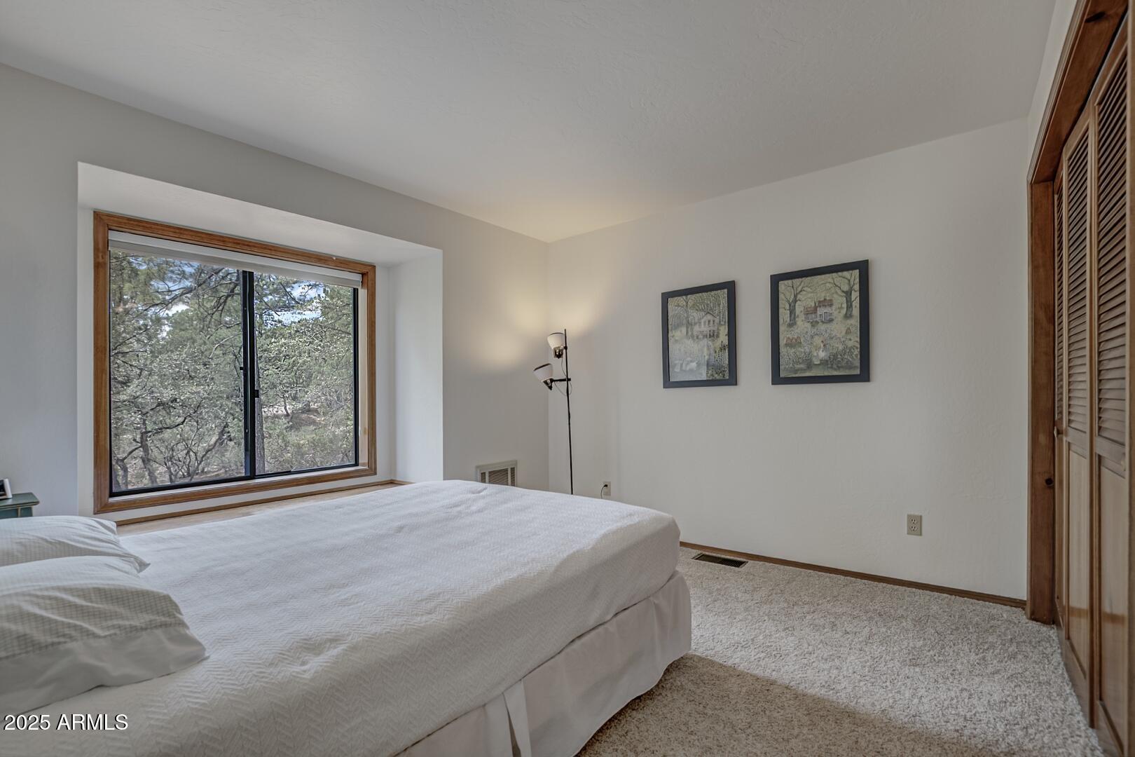 5838 Arroyo Way Pine, AZ 85544 - Photo 15 of 53 a bedroom with a large bed and a large window