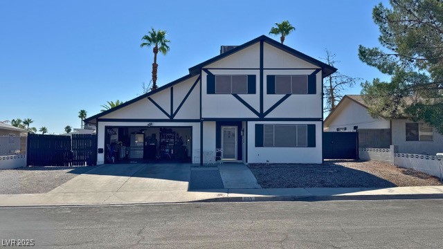 809 Peacock Court Las Vegas, NV 89145 - Photo 2 of 15 Tudor-style house with driveway, a gate, an attached garage, and stucco siding