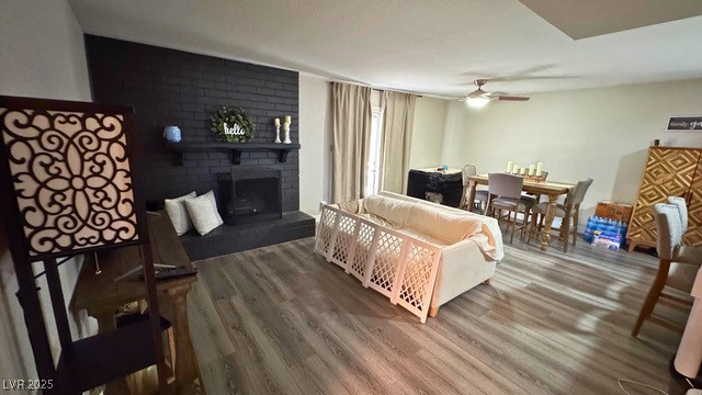 809 Peacock Court Las Vegas, NV 89145 - Photo 3 of 15 Living area featuring luxury vinyl plank floors, a brick fireplace, and ceiling fan