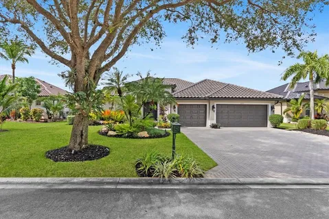 a front view of a house with a garden and trees