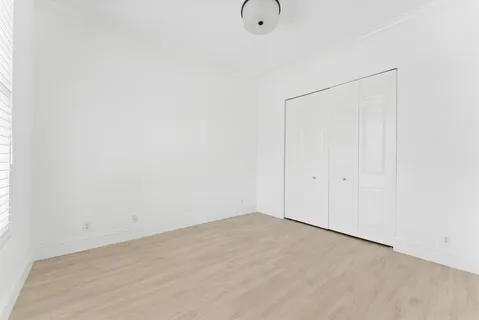 a view of a swimming pool with a yard and palm trees