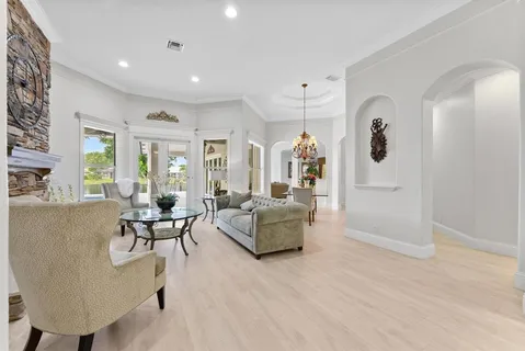 a living room with furniture a fireplace and a chandelier