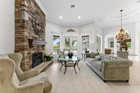 a living room with furniture a fireplace and a large window