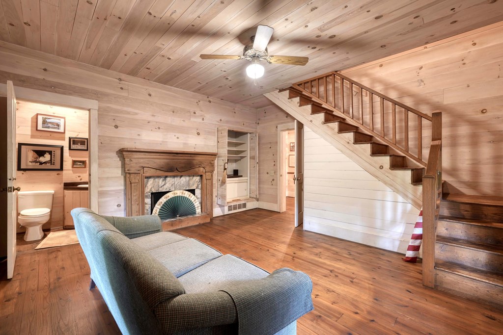 2350 Dial Road Blue Ridge, GA 30513 - Photo 26 of 76 a view of a livingroom with furniture a fireplace wooden floor and staircase