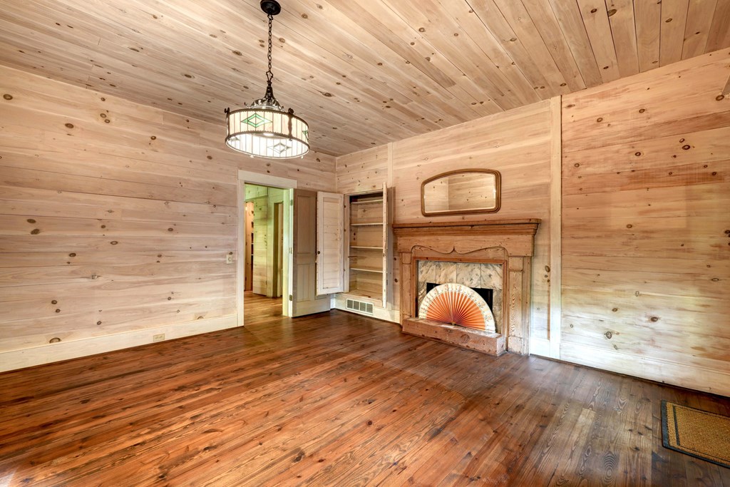 2350 Dial Road Blue Ridge, GA 30513 - Photo 28 of 76 a view of an empty room with wooden floor and a fireplace