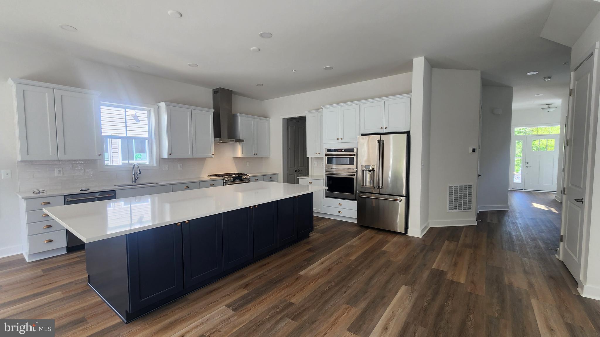 126 Sadie Way Arnold, MD 21012 - Photo 12 of 41 a kitchen with stainless steel appliances granite countertop a refrigerator a sink dishwasher a stove and white countertops with wooden floor