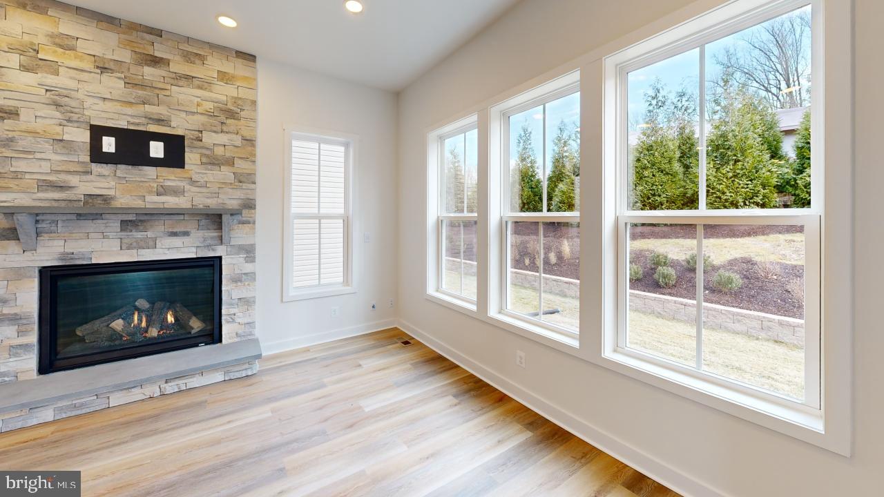 126 Sadie Way Arnold, MD 21012 - Photo 16 of 41 a living room with a fireplace with a floor to ceiling window hardwood floor