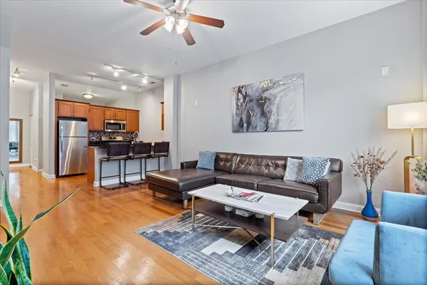 a living room with furniture and a view of kitchen