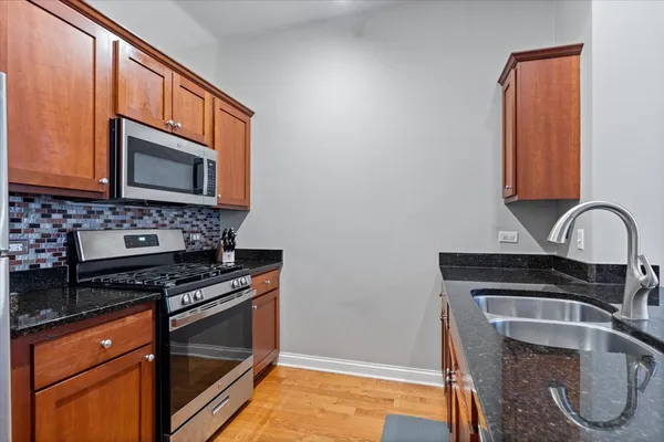 a kitchen with granite countertop a stove and a microwave