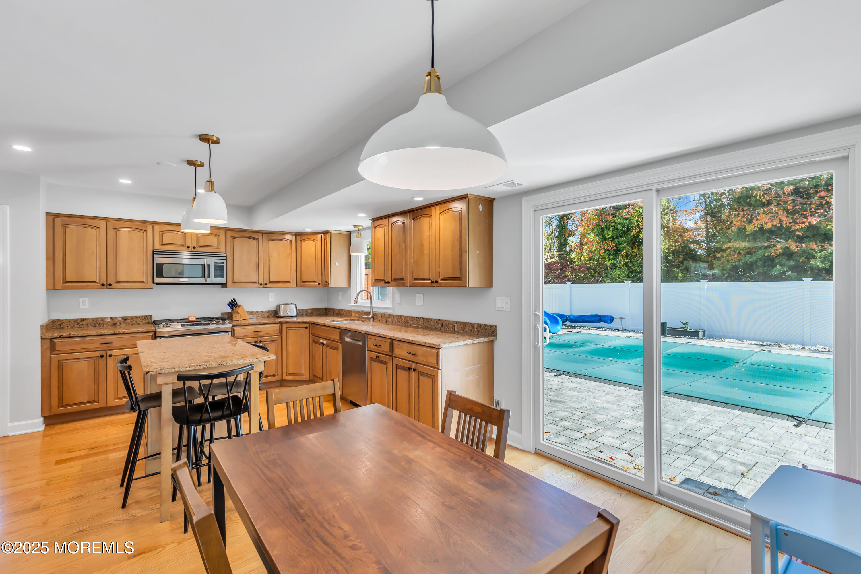 8 Allston Street Red Bank, NJ 07701 - Photo 20 of 64 a view of a kitchen with kitchen island granite countertop a stove a sink a refrigerator dining table and chairs with wooden floor
