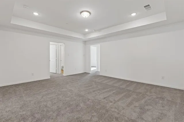 an empty room with white cabinet and mirrors