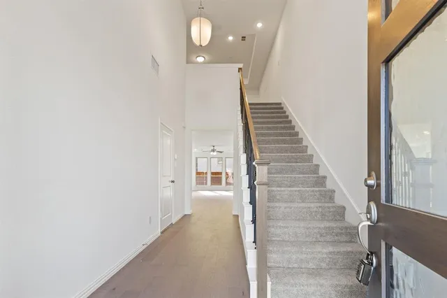 an empty room with windows and ceiling fan