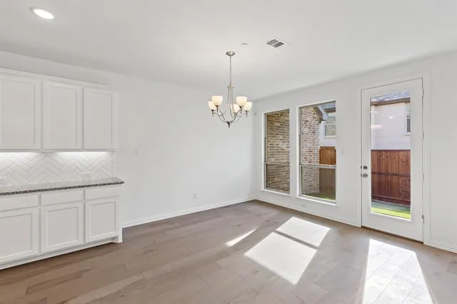 a large white kitchen with a refrigerator a stove and white cabinets