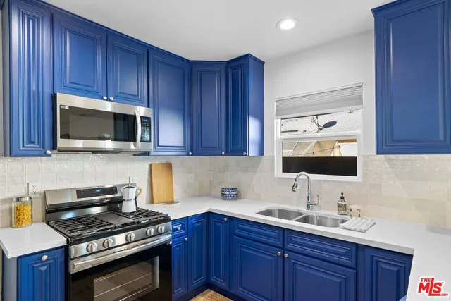 a bathroom with a granite countertop sink and a large mirror