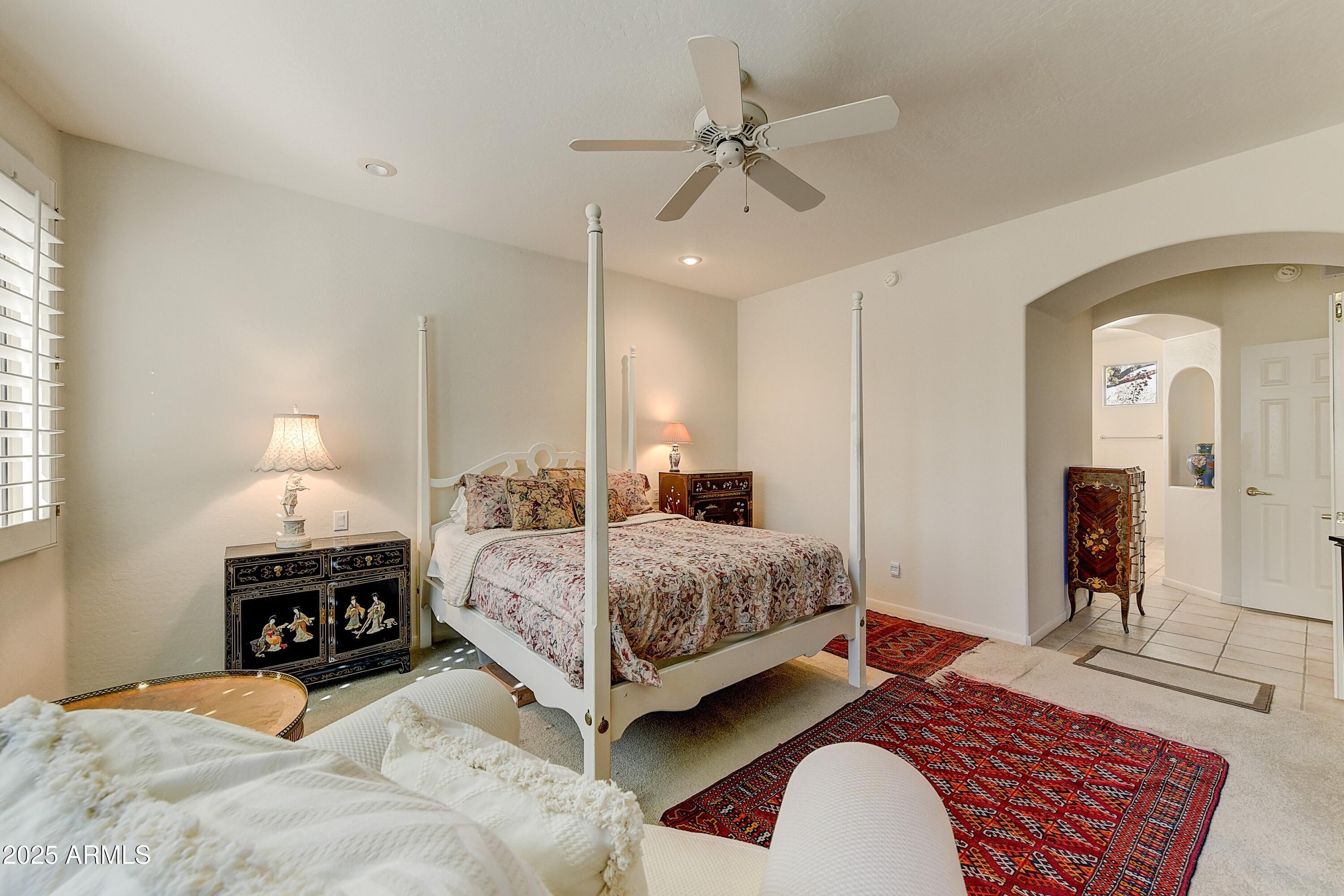 27502 North Azatlan Drive Rio Verde, AZ 85263 - Photo 8 of 21 a bedroom with a bed a ceiling fan and a dresser