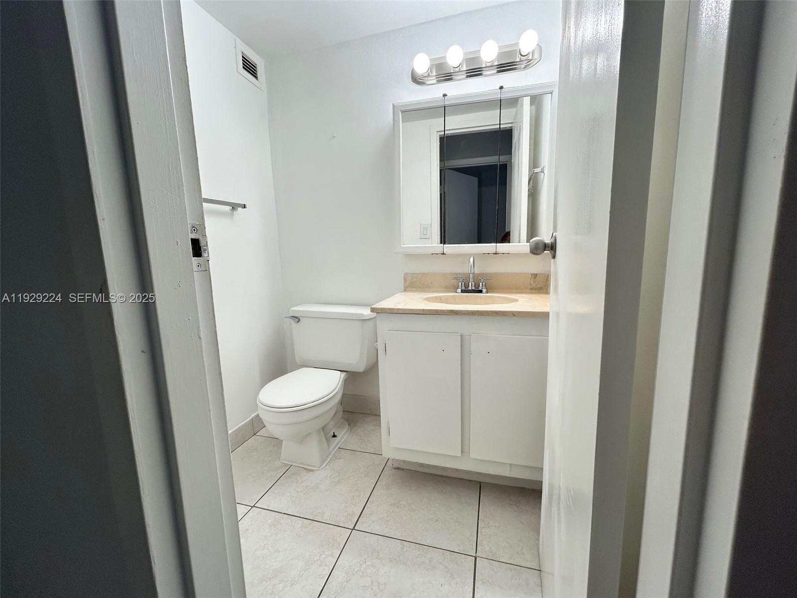16919 North Bay Road, Unit 214 Sunny Isles Beach, FL 33160 - Photo 24 of 42 a bathroom with a toilet a sink and mirror