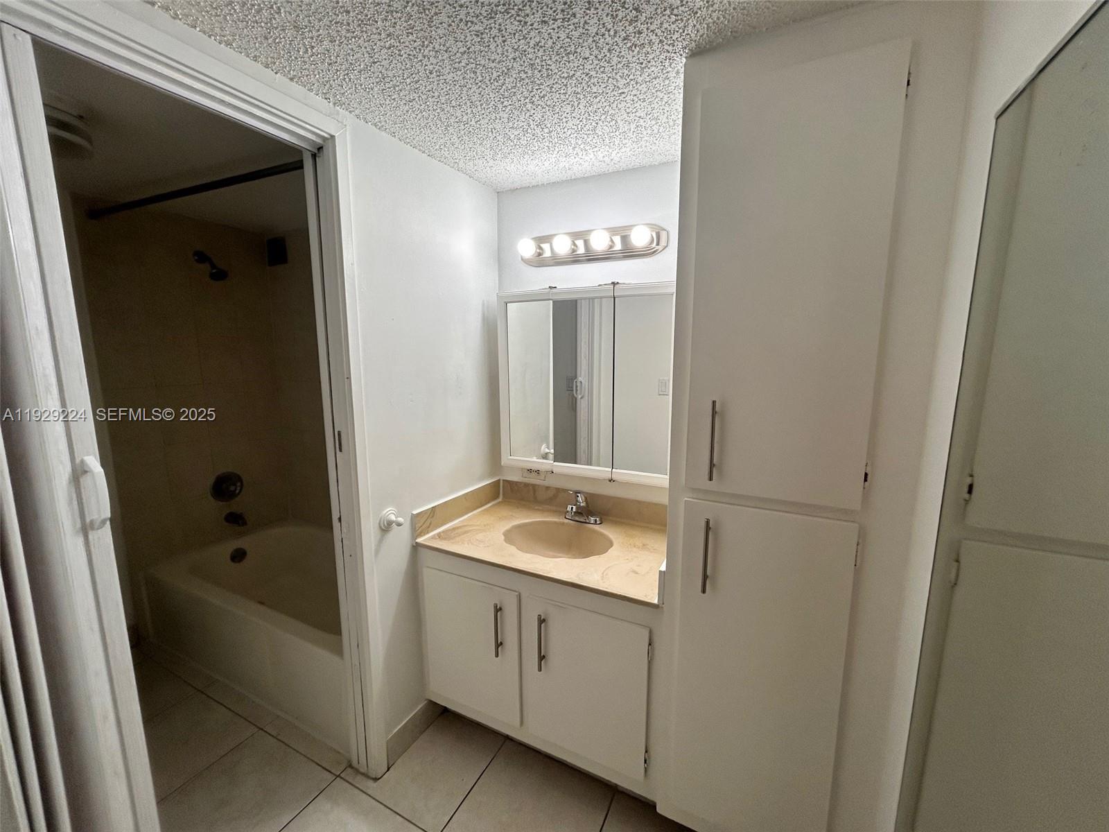 16919 North Bay Road, Unit 214 Sunny Isles Beach, FL 33160 - Photo 26 of 42 a bathroom with a granite countertop sink and a bathtub