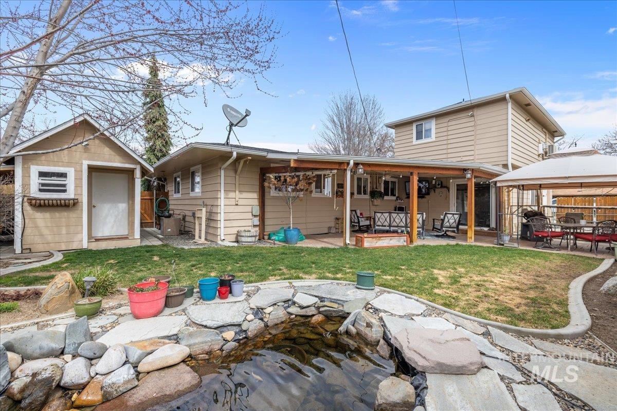 712 Southwest 4th Street Fruitland, ID 83619 - Photo 2 of 21 Back of house with a patio area, a storage shed, and a small pond
