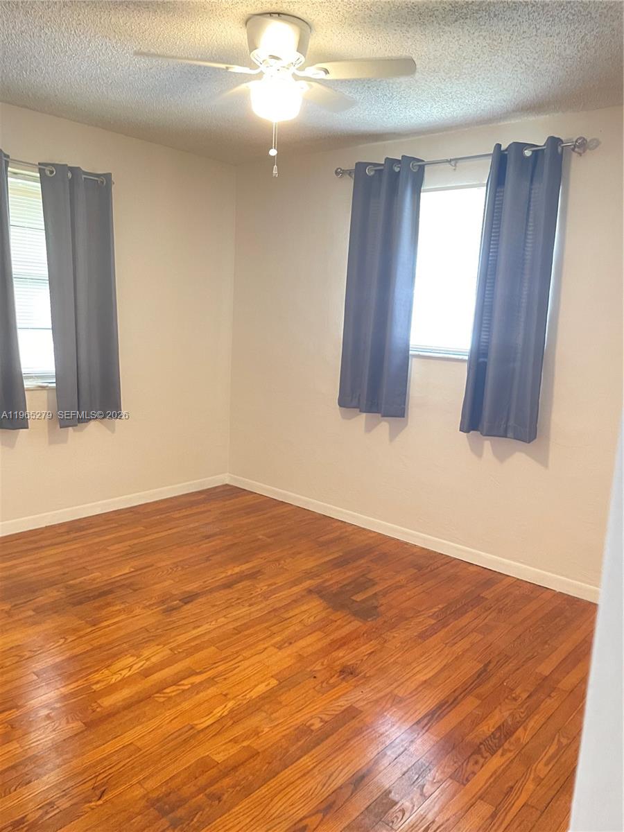 1913 Harding Street Hollywood, FL 33020 - Photo 4 of 9 a view of an empty room with wooden floor and fan
