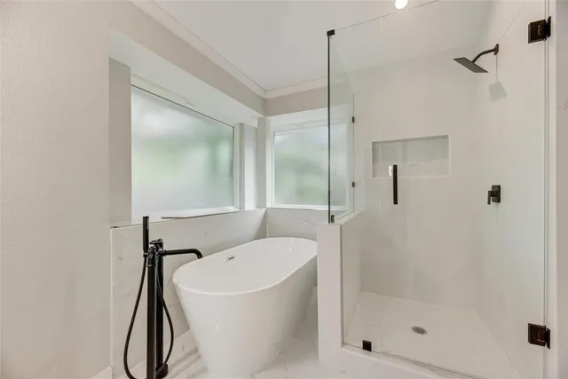 a bathroom with a tub shower and a sink