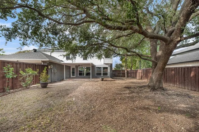 a view of a house with a tree in front of it
