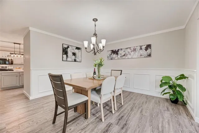 a view of a dining room with furniture wooden floor and chandelier