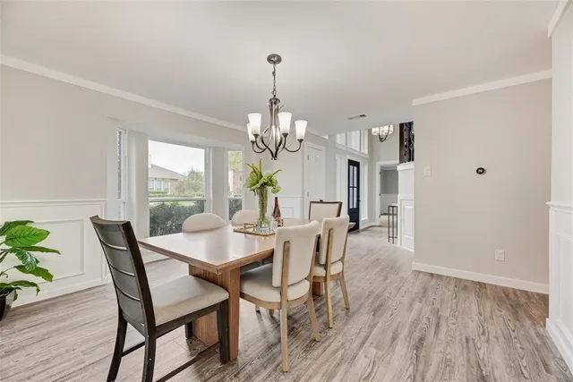a view of a dining room with furniture a chandelier and wooden floor
