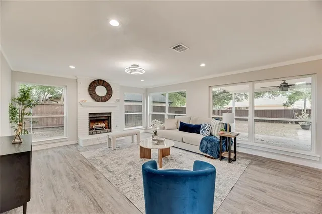 a living room with furniture a fireplace and a large window